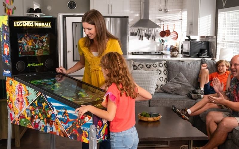 A family playing a Legends Pinball cabinet in their living room