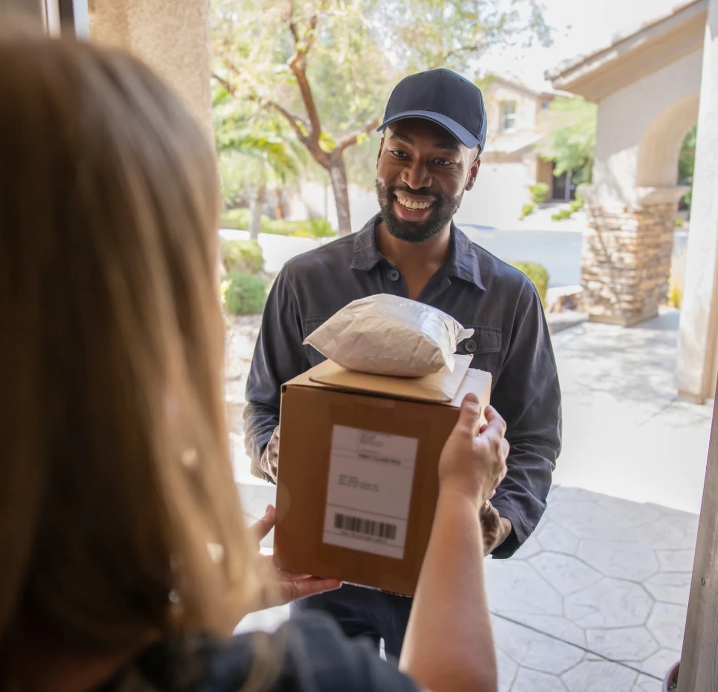 A courier handing a package to a customer at their front door