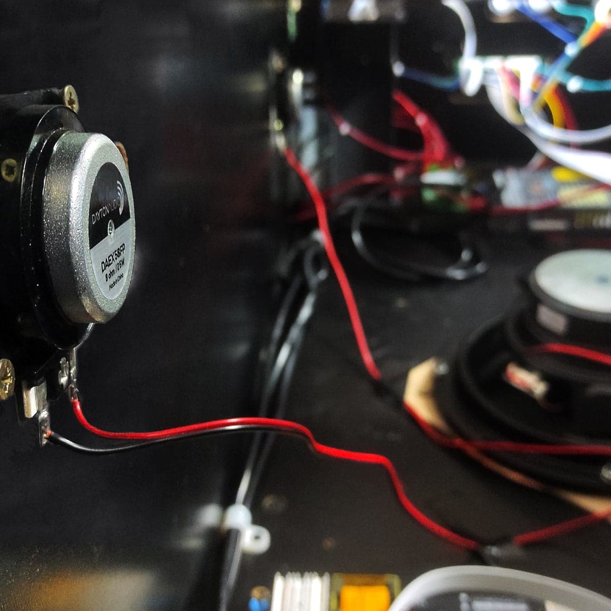 An SSF Kit sound exciter wired in place inside a pinball cabinet